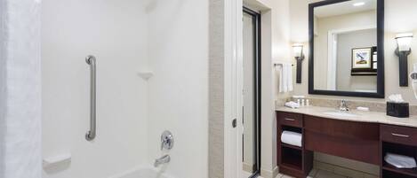 Un baño moderno con cabina de ducha, tocador con espejo grande y bañera.