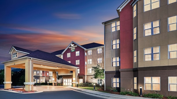A hotel with a covered entrance, multiple floors, and a well-lit facade.