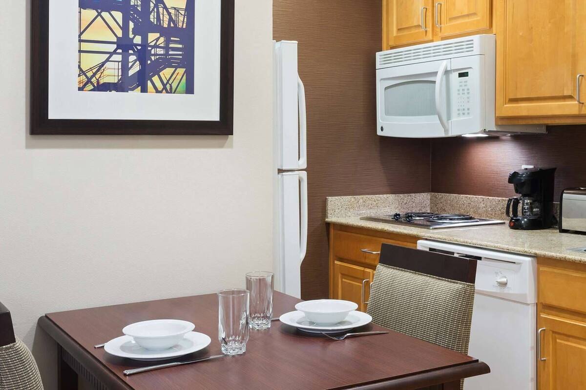A compact kitchen with a microwave, toaster, coffee maker, and dishwasher.
