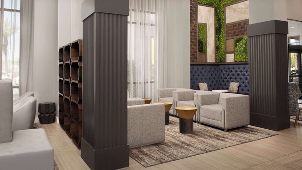 A modern living room with a sectional sofa, a tufted headboard, and a built-in green wall. - Hilton Phoenix Chandler (Chandler)