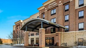A Hampton Inn & Suites building with a brick facade, a covered entrance, and a clear blue sky. - Hampton Inn & Suites Detroit-Canton (Canton)