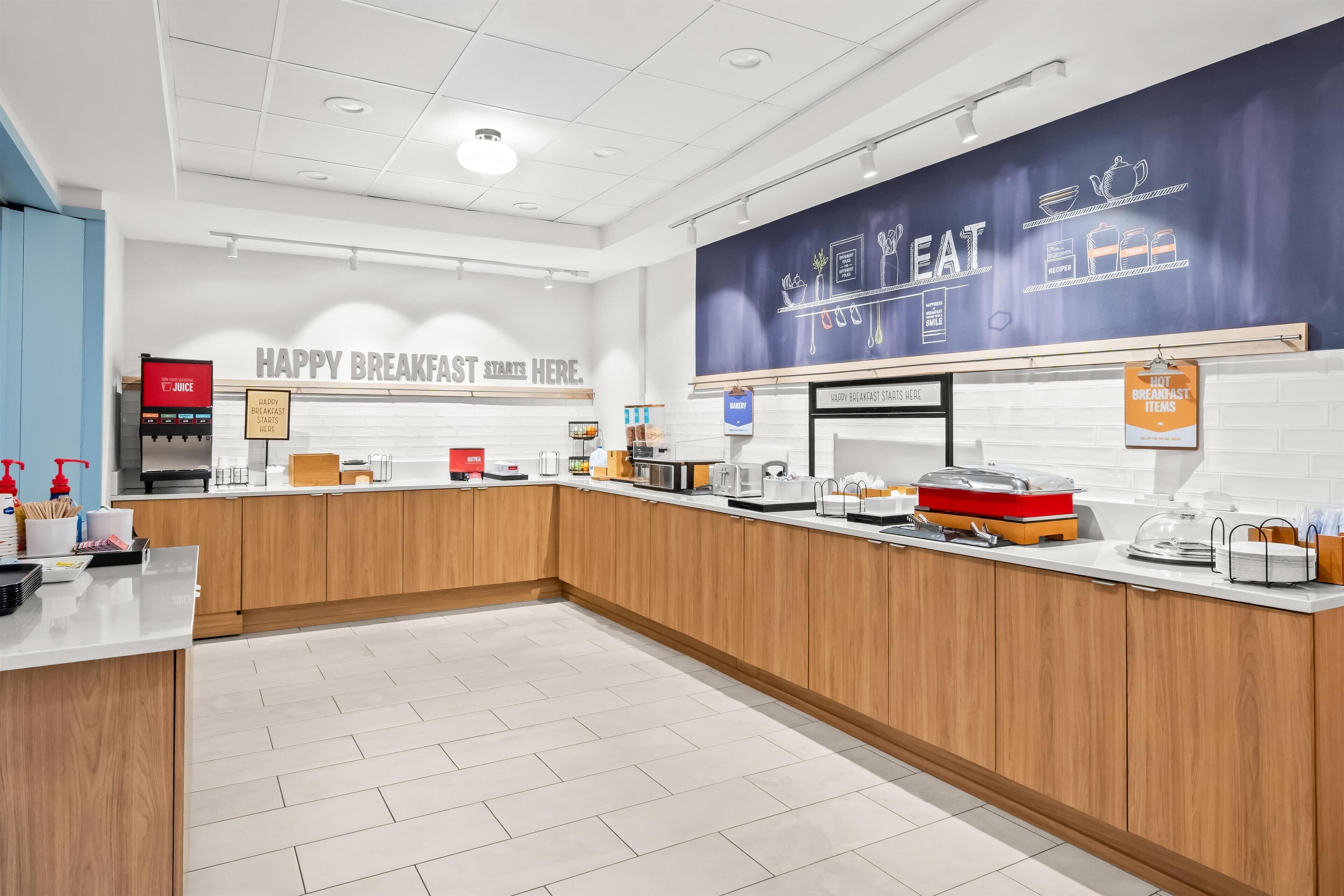 A modern breakfast area with a counter, coffee machine, and various breakfast items.