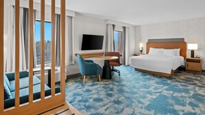 A hotel room with a bed, a desk, a TV, a chair, and a view of the outdoors. - Hampton Inn & Suites Detroit-Canton (Canton)