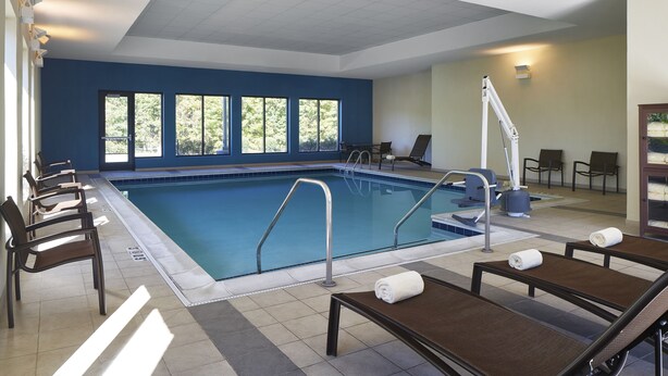 A swimming pool with lounge chairs and a lifeguard stand.
