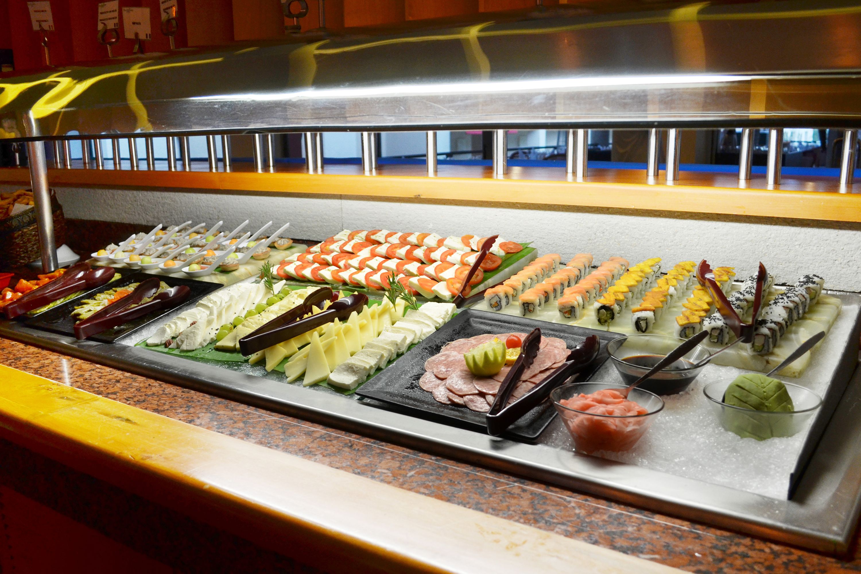 A buffet with various food items including sushi, sashimi, and other dishes.