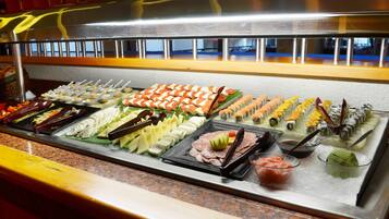 A buffet with various food items including sushi, sashimi, and other dishes.