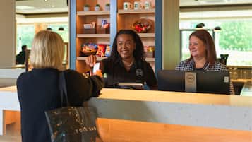 A reception desk with a counter, shelves with snacks, and a coffee machine.