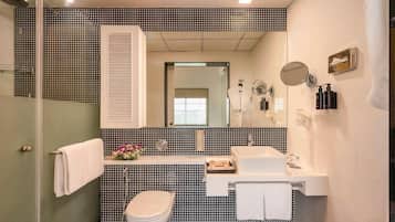 A bathroom with a toilet, sink, and shower.