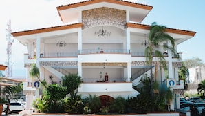 A multi-story building with a stone facade, balconies, and a central courtyard. - Hotel Maria Isabel (Colima)