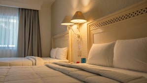 A hotel room with two beds, a large window with curtains, and wall-mounted lamps. - Hotel Maria Isabel (Colima)