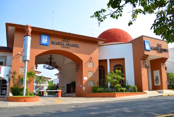 The entrance to Maria Isabel Hotel with a prominent archway and a red dome.