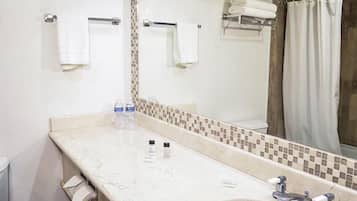 Bathroom features a sink, toilet, and shower, with a towel rack and amenities.