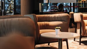 Un área de descanso moderna con sofás de cuero, una mesa redonda y una planta en maceta.