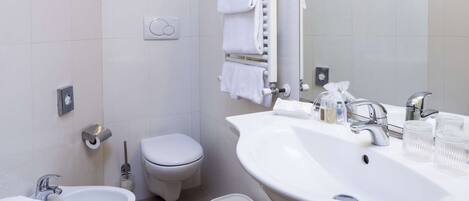 A modern bathroom with a bidet, toilet, and two sinks.