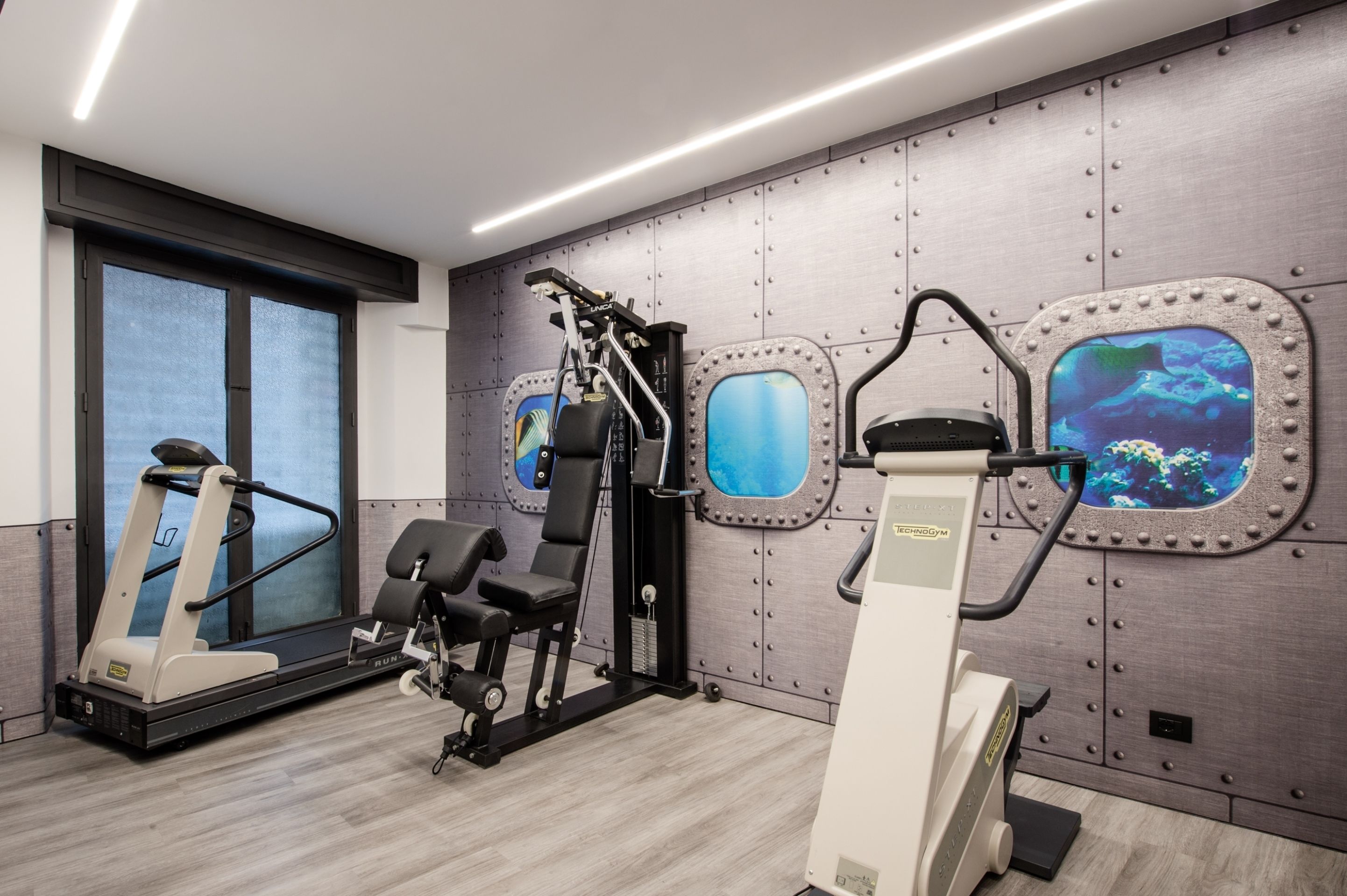 A modern gym with a treadmill, weight machines, and a stationary bike.