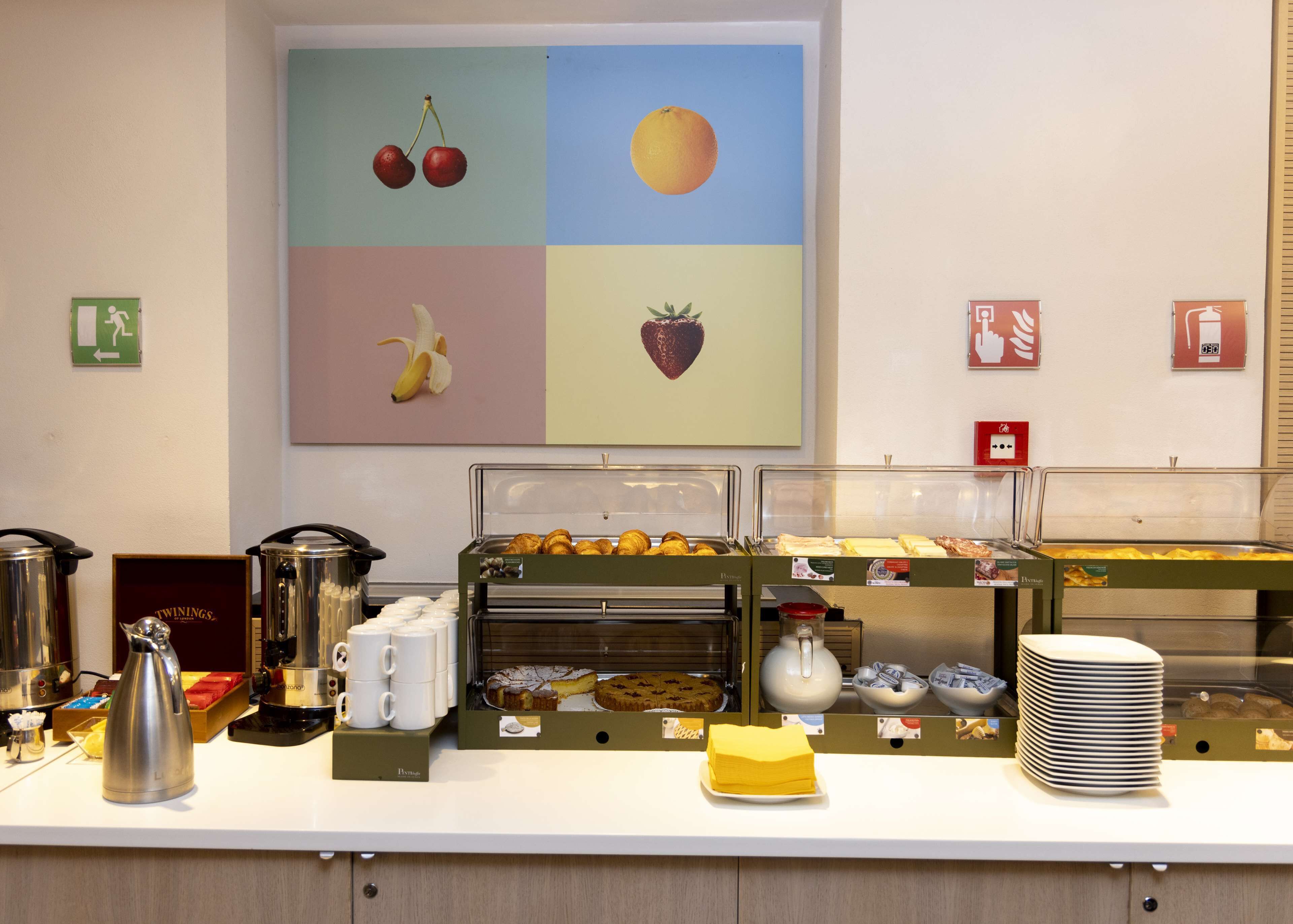 Een ontbijtbuffet met diverse soorten eten en koffieapparaten.