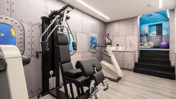 Ein modernes Fitnessstudio mit Trainingsgeräten, einer Wandmalerei und einer Treppe.