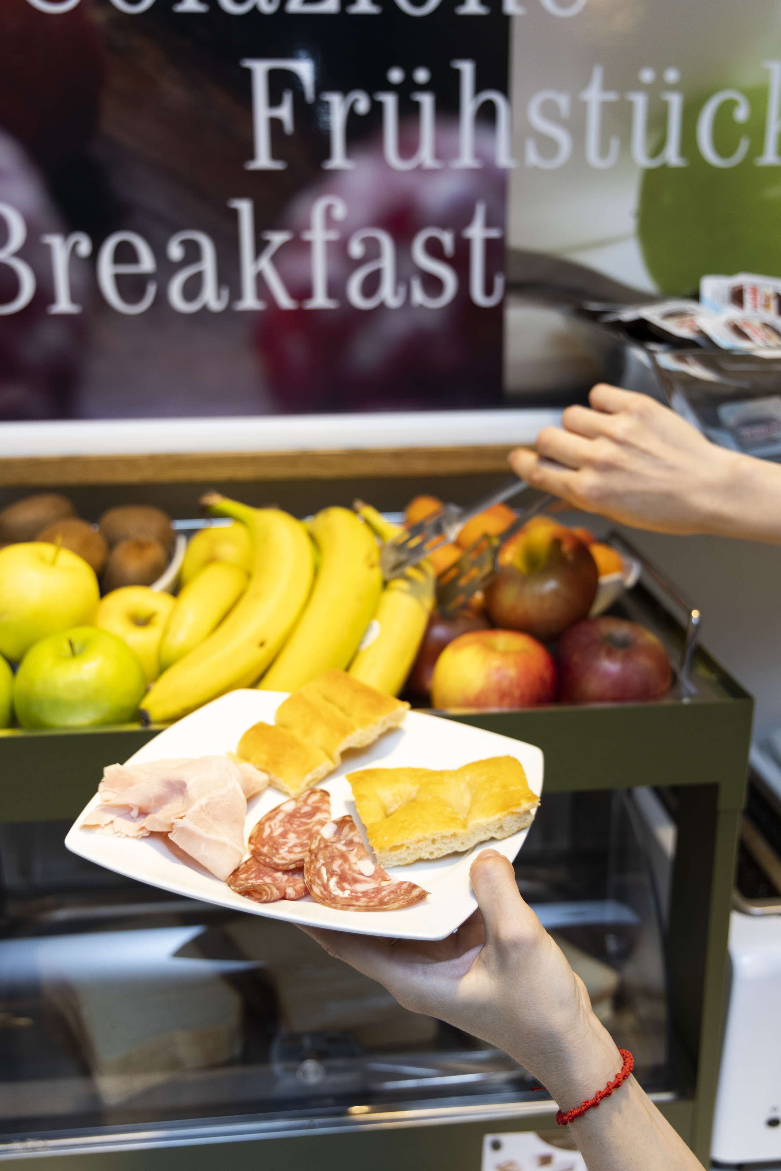 Una barra de desayuno con diversas frutas y bollería.