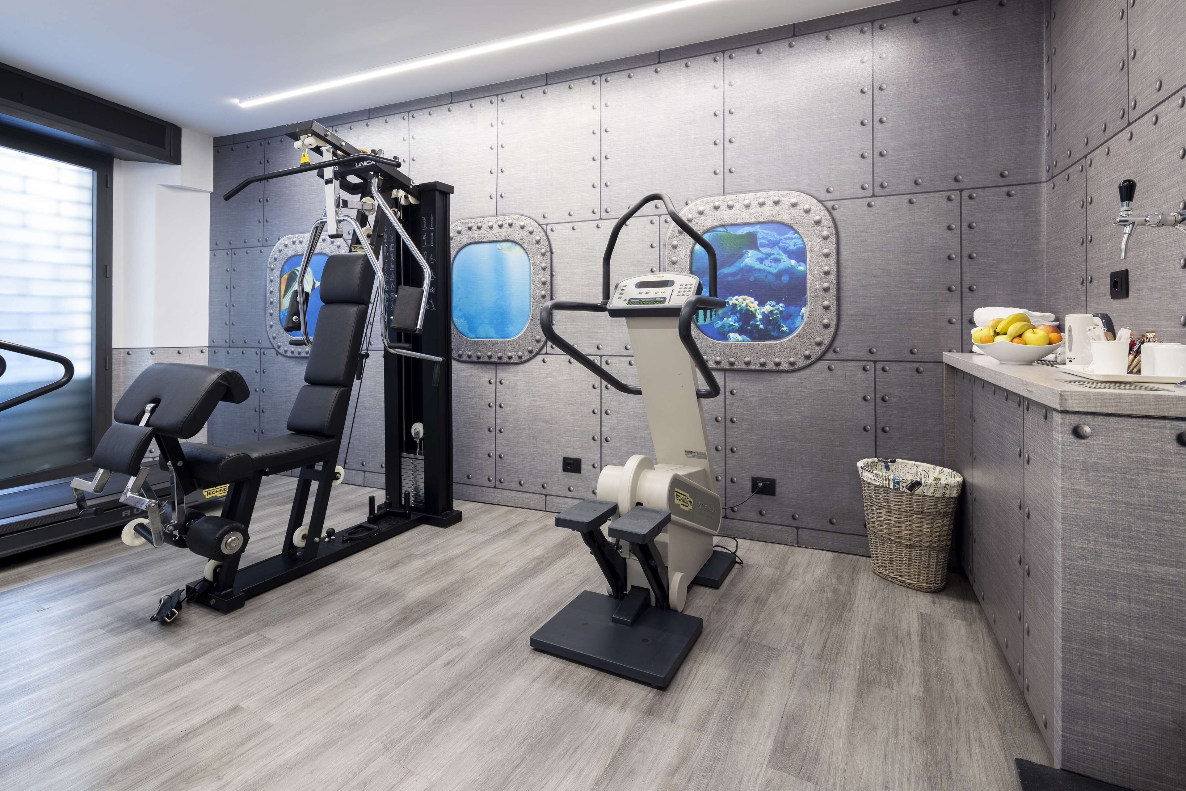 Une salle de sport moderne équipée de matériel d’exercice, d’un tapis de course et d’un mur agrémenté de fenêtres sur le thème de la navigation.