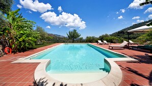 A rectangular swimming pool with a tiled deck, surrounded by lounge chairs and a white canopy. - Casale Romano Resort (Motta Camastra)