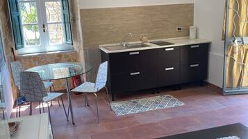 Una cocina moderna con un lavamanos, armarios y un comedor con sillas y una mesa.