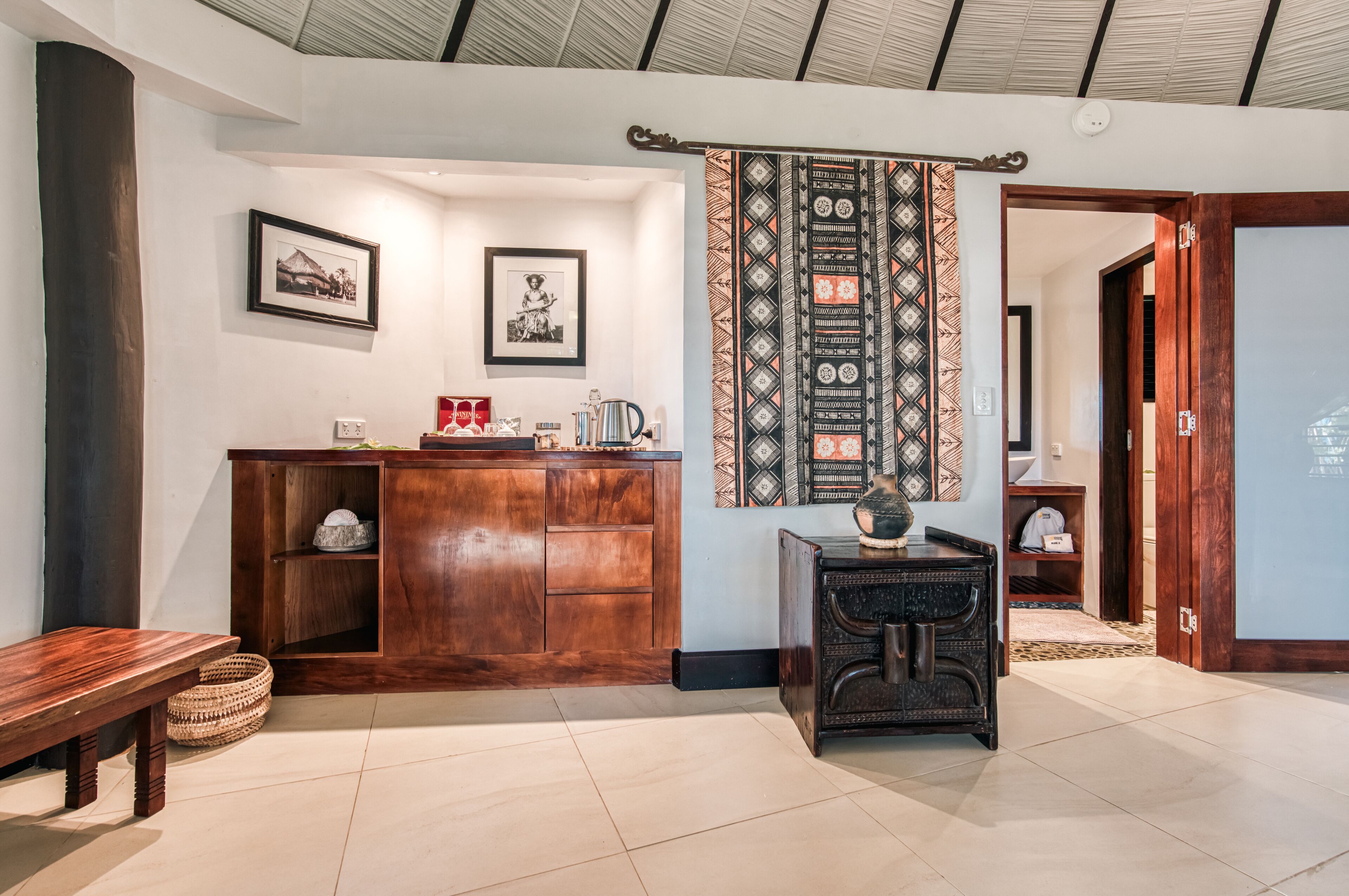 A reception area with a wooden desk, framed pictures on the wall, and a patterned curtain.