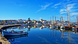 A marina with boats docked, calm water, and buildings in the background. - Hotel Cala di Seta (Calasetta)