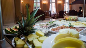 Un bufé con diversos alimentos, como frutas, quesos y embutidos.