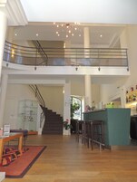 Un intérieur spacieux à plusieurs niveaux, comprenant un escalier, un coin bar et un espace salon.