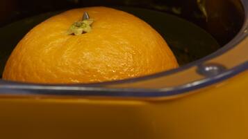An orange in a yellow container.