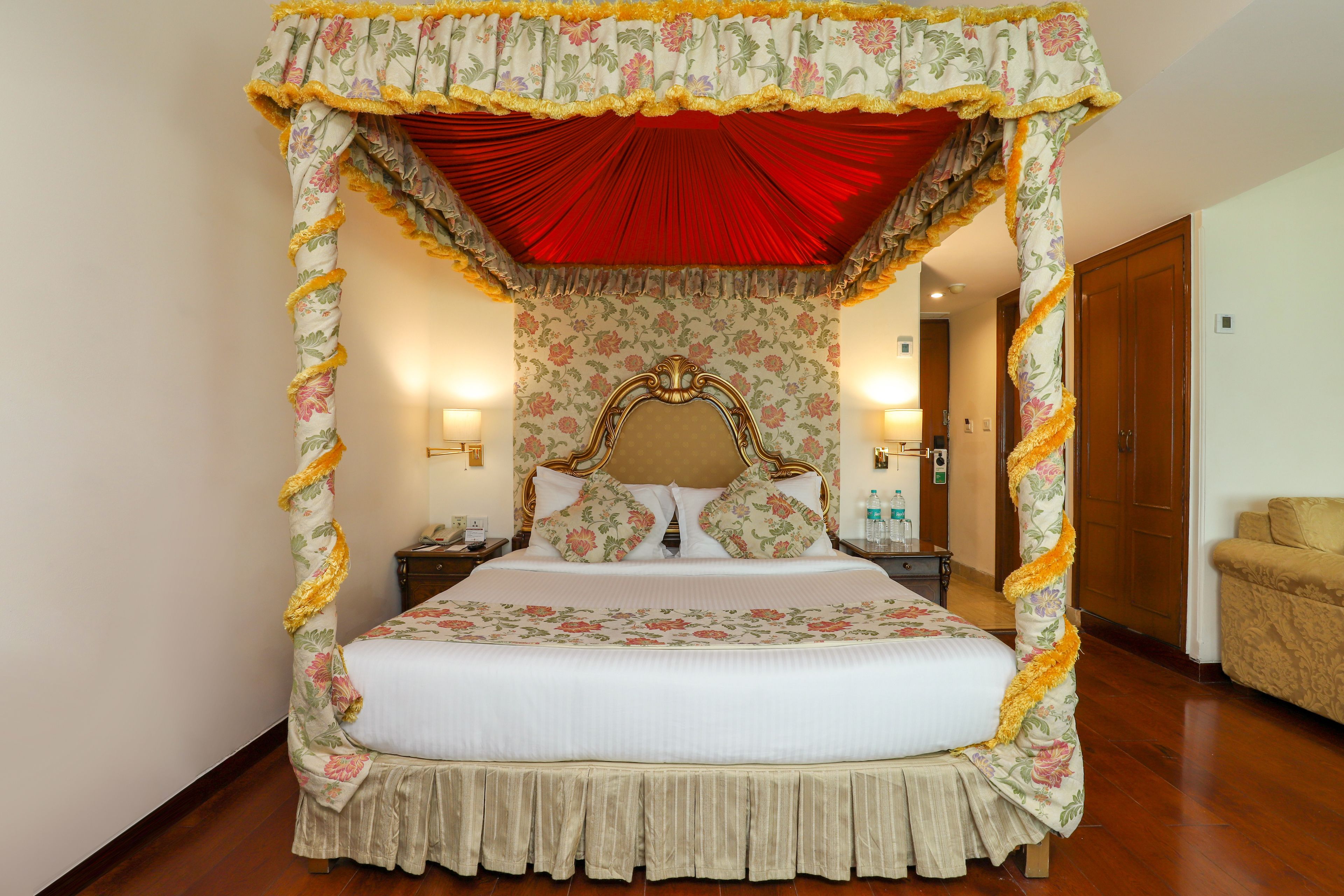 Een hemelbed met bloemenbedekte matrassen en een rode hemel.