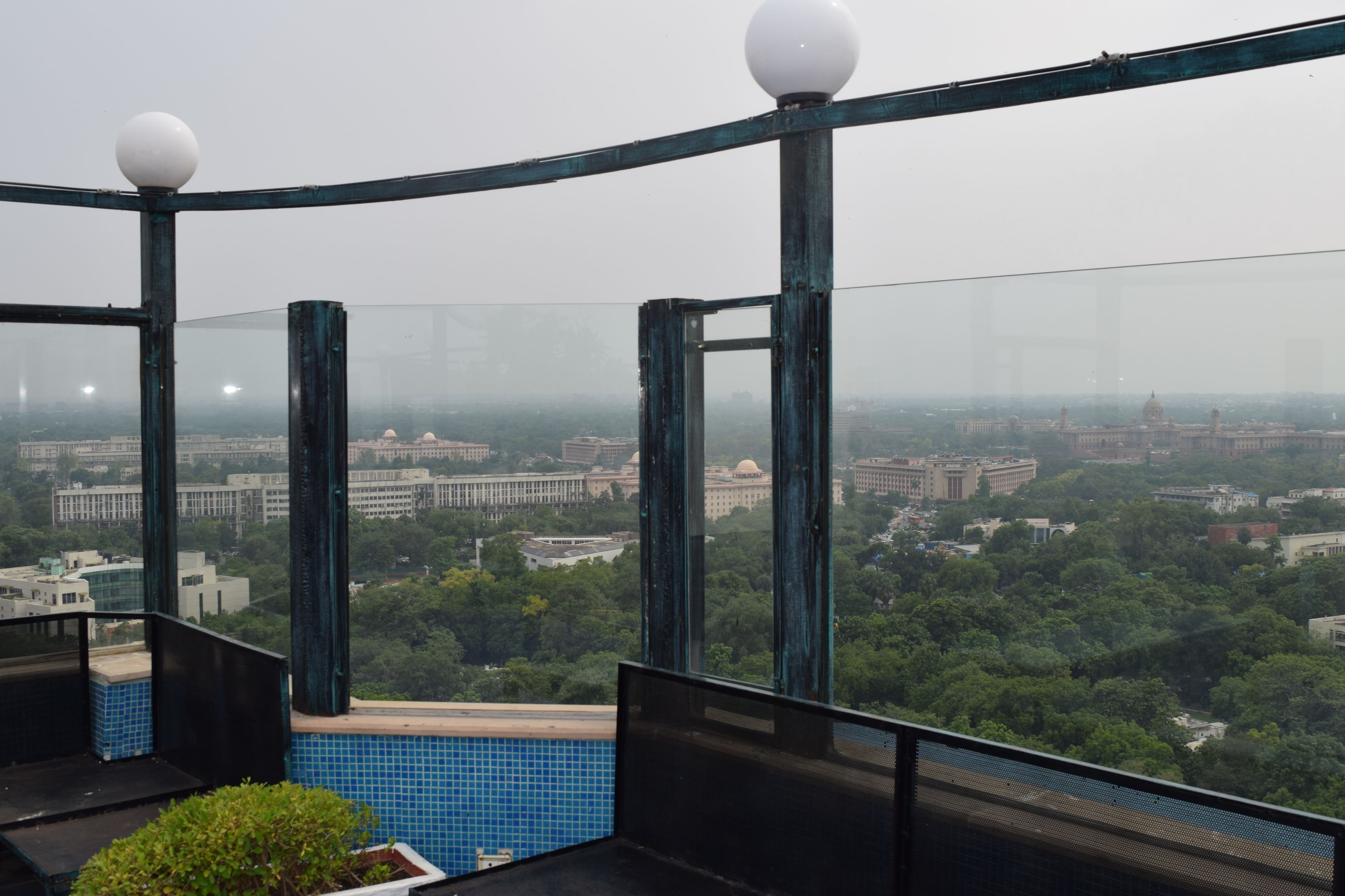 Un edificio alto con vistas a un paisaje urbano y zonas verdes.