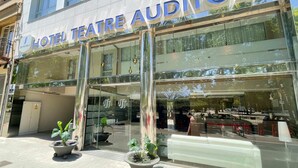 L’extérieur de l’hôtel Teatre Auditori se distingue par sa façade moderne, avec de grandes fenêtres en verre et une entrée imposante.