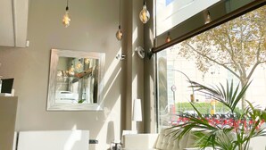 Un intérieur moderne avec un canapé, un grand miroir et des luminaires suspendus.