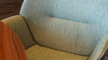 A close-up of a chair with a textured fabric in shades of blue and yellow.
