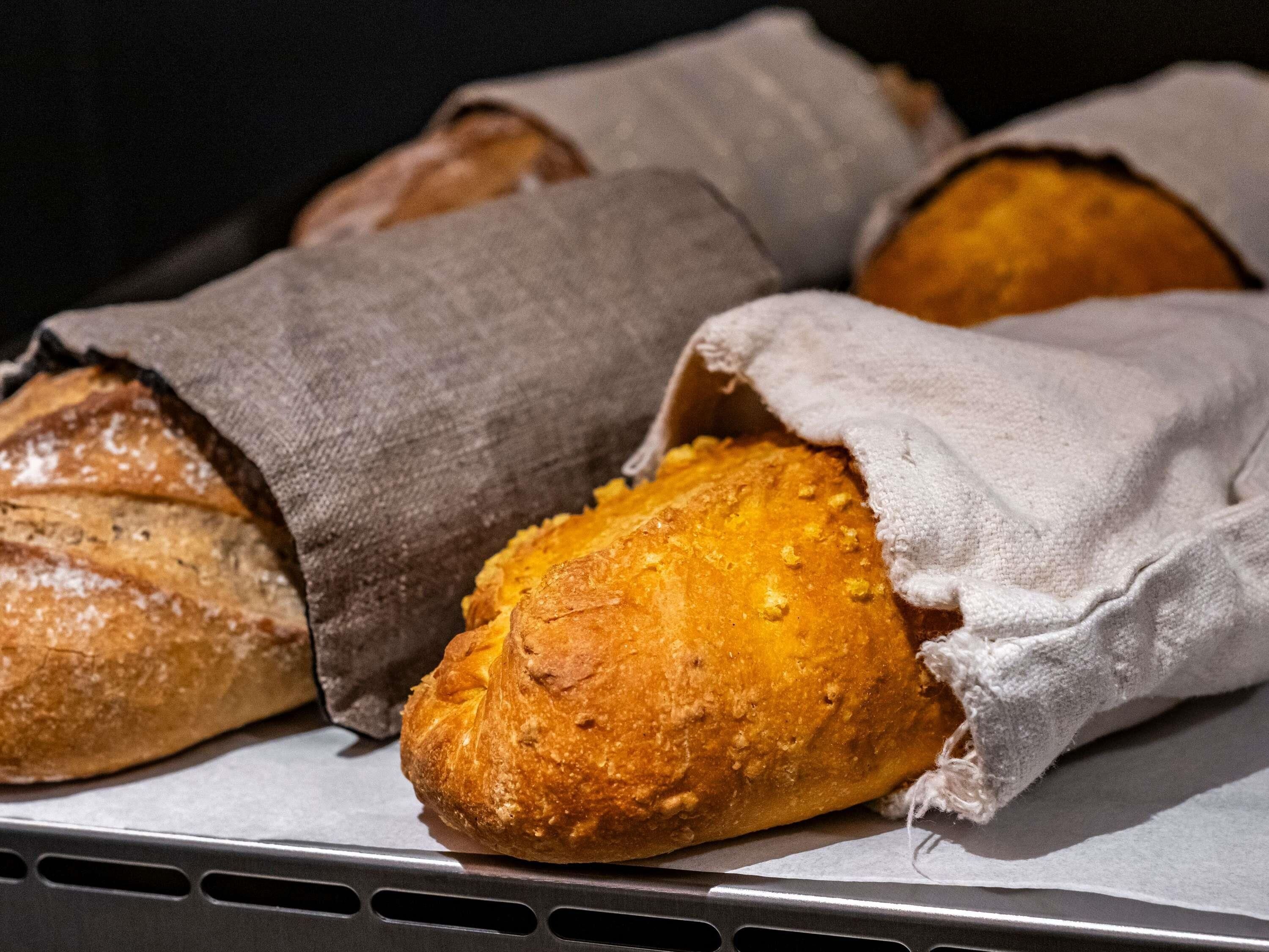 Ein Tablett mit frisch gebackenen Brötchen, in Stoff gewickelt.