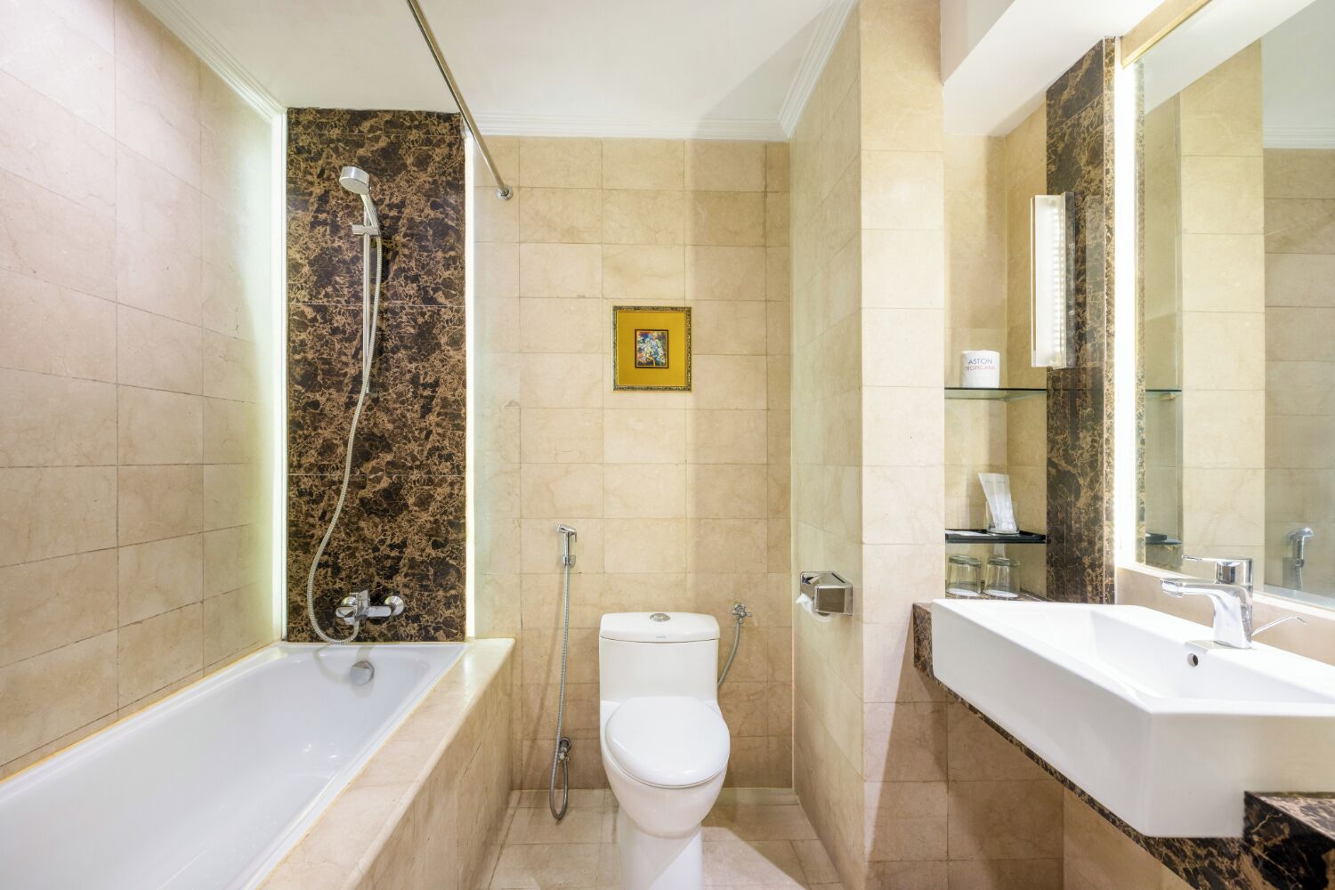 A bathroom with a bathtub, toilet, and a large mirror.