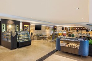 Een hotel lobby met een vitrine voor sieraden, een zithoek en een buffet.