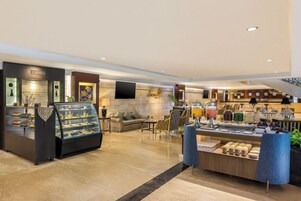 Vestíbulo de hotel con una vitrina de joyería, zona de estar y un bufé.