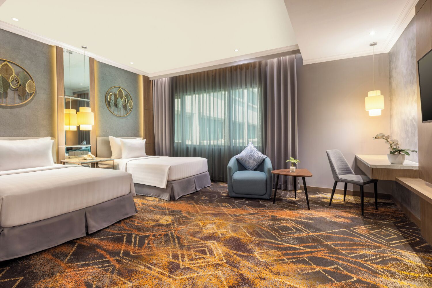 A hotel room with two beds, a desk, a chair, a small table, and a large window with curtains.