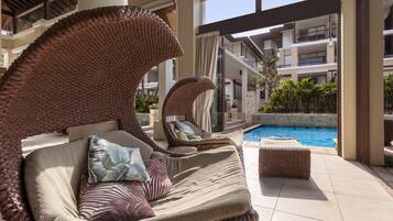 A poolside area with wicker lounge chairs and a pool.