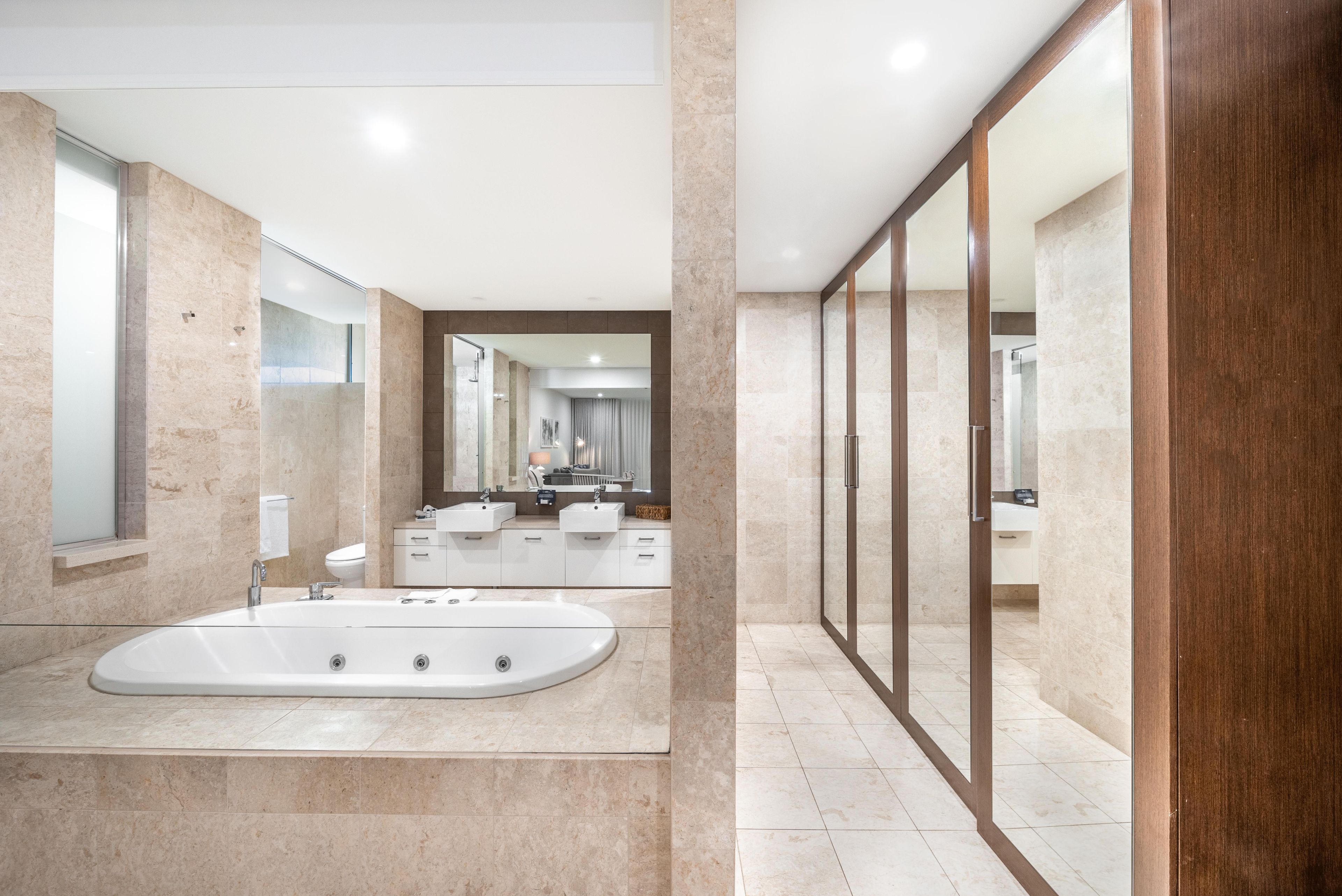 Une salle de bain moderne avec une baignoire sur pieds, un grand miroir et une douche à l’italienne.