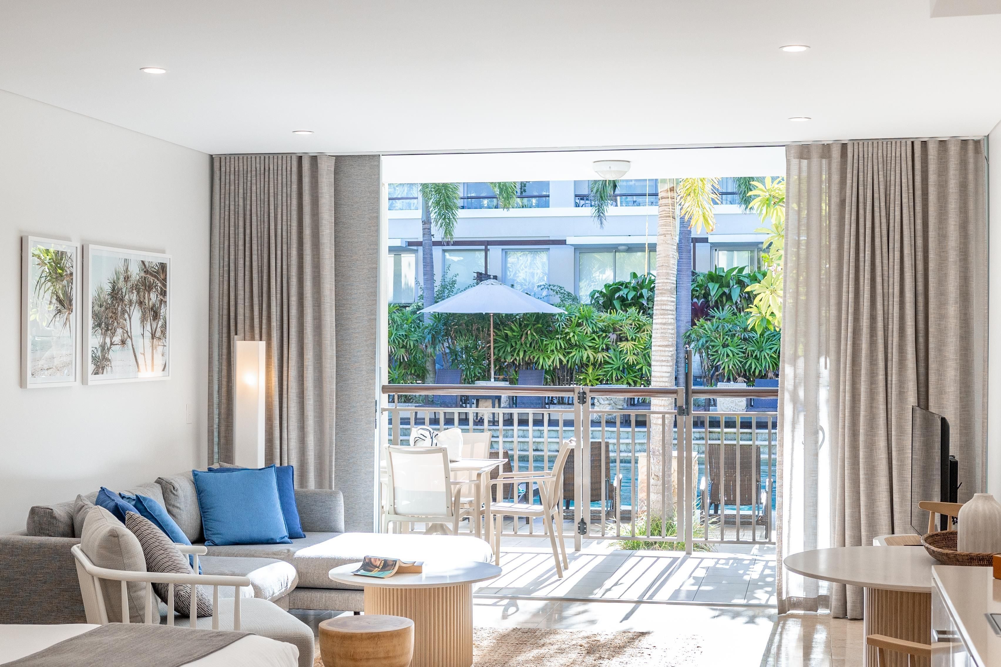 A modern living room with a balcony, a sofa set, a coffee table, and a dining area.