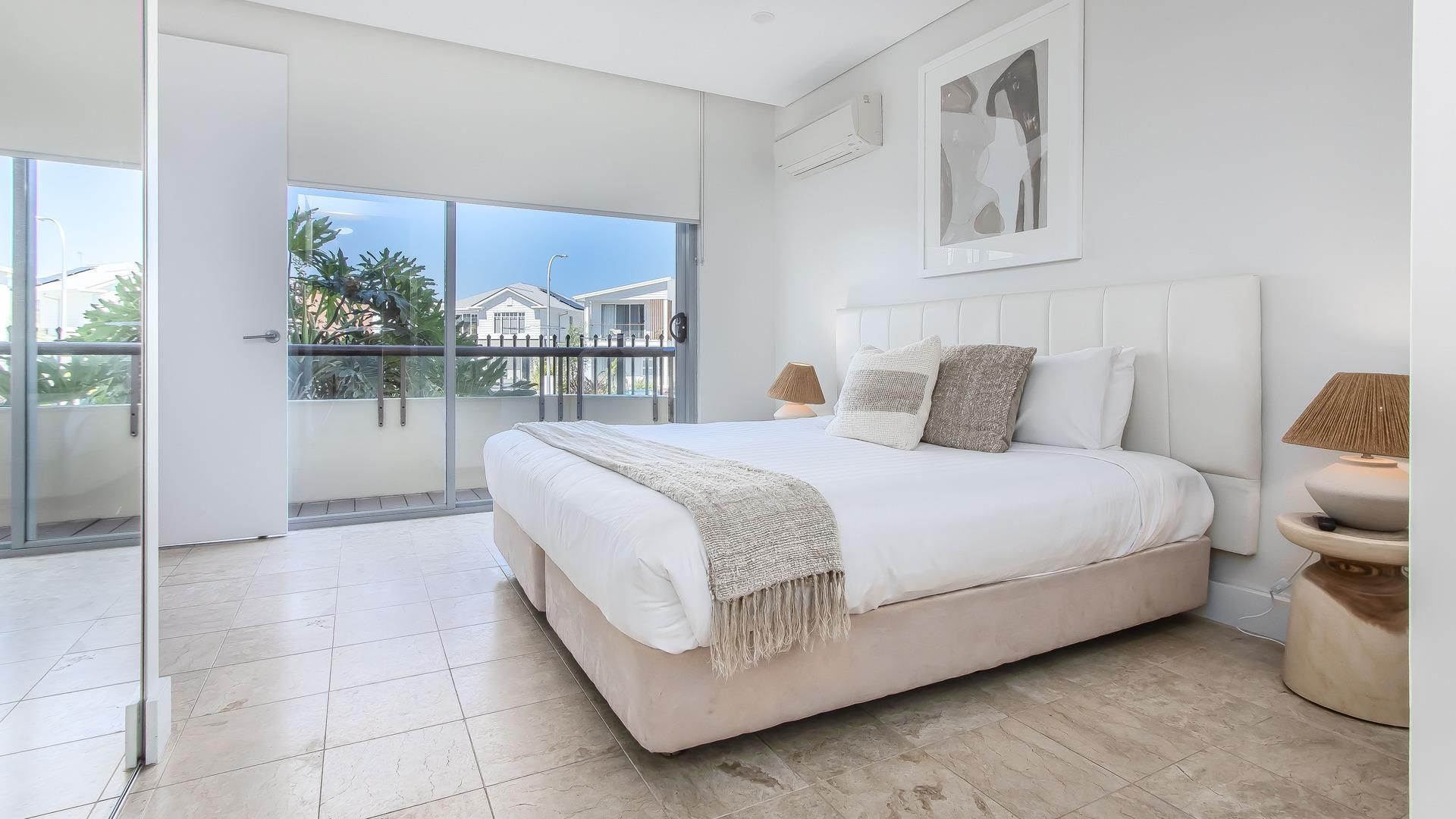 Un dormitorio con una cama grande, un balcón con vistas y un diseño moderno.