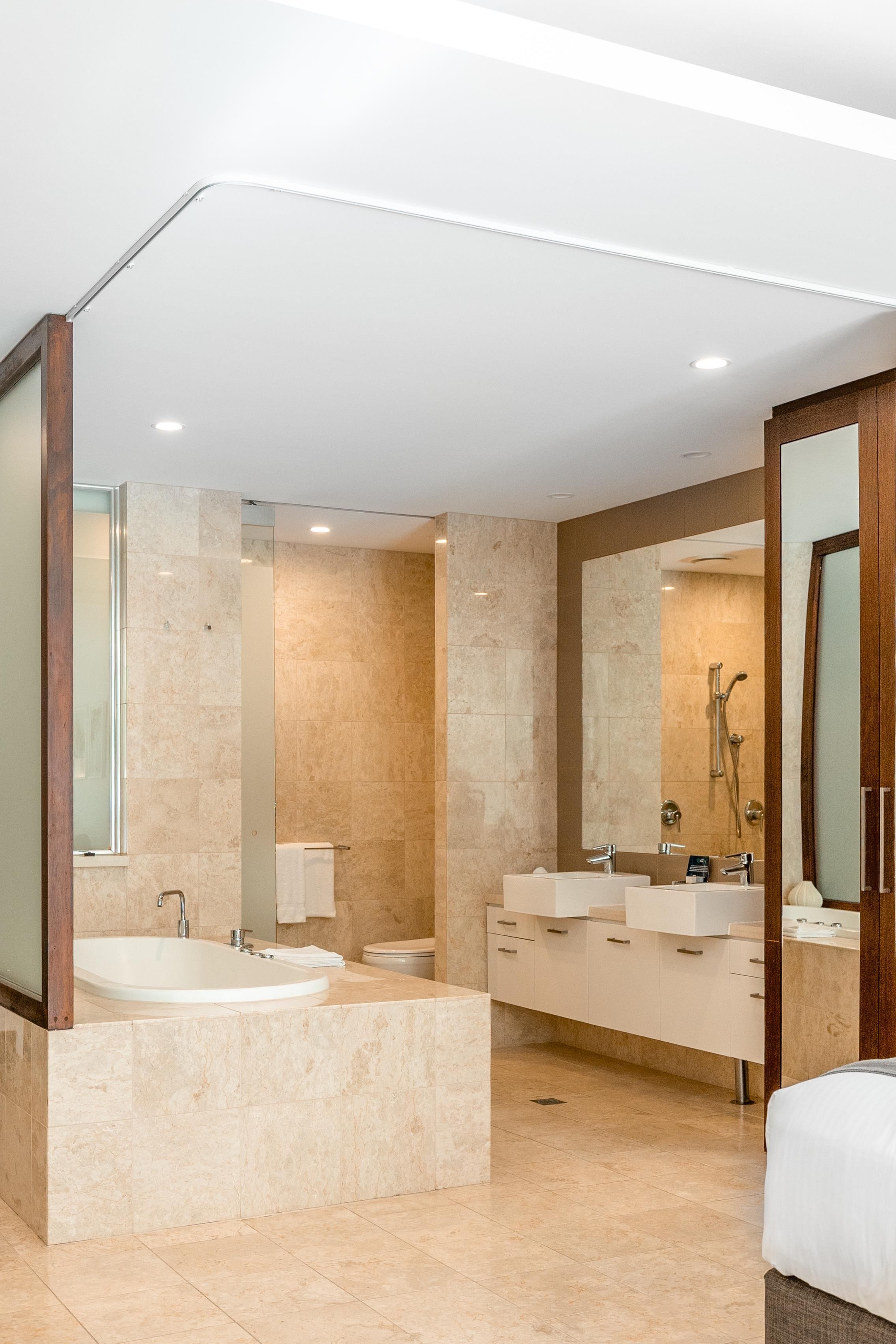A modern bathroom with a large bathtub, a double sink vanity, and a walk-in shower.