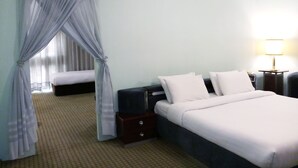 Quarto de hotel com cama, mesas de cabeceira, abajur e janela com cortinas.