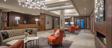 A spacious lobby with a reception desk, seating area, and modern lighting fixtures.