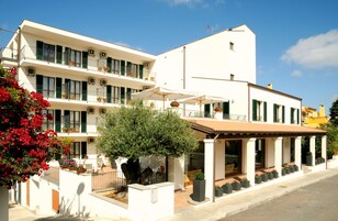 A two-story building with balconies, outdoor seating, and potted plants.