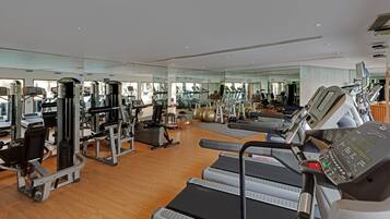 Ein geräumiges Fitnessstudio mit Laufbändern, Kraftgeräten und Gymbällen.