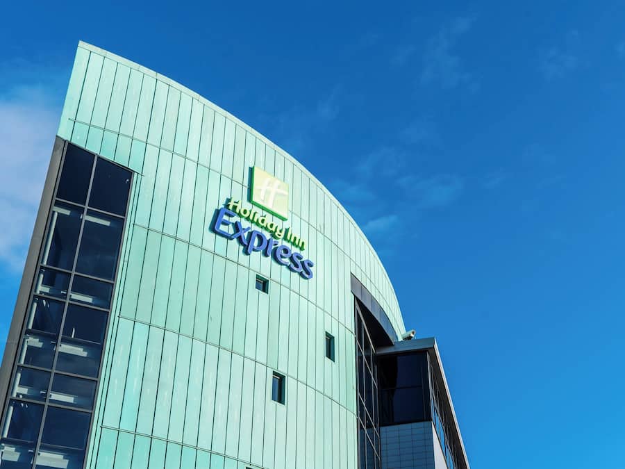 Un edificio moderno con fachada curva y un cartel que dice 'Holiday Inn Express'.